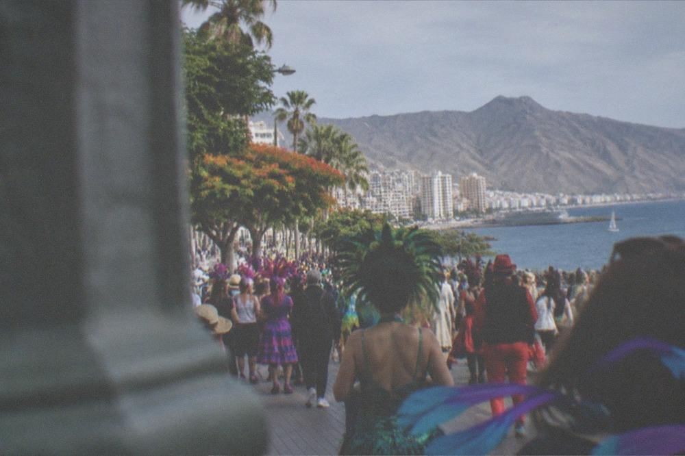 A crowd in costume at an outdoor carnival celebration