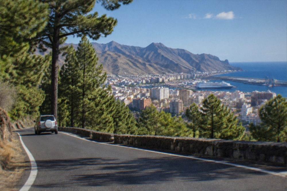 A road winding through pine forest towards volcanic mountains in Tenerife