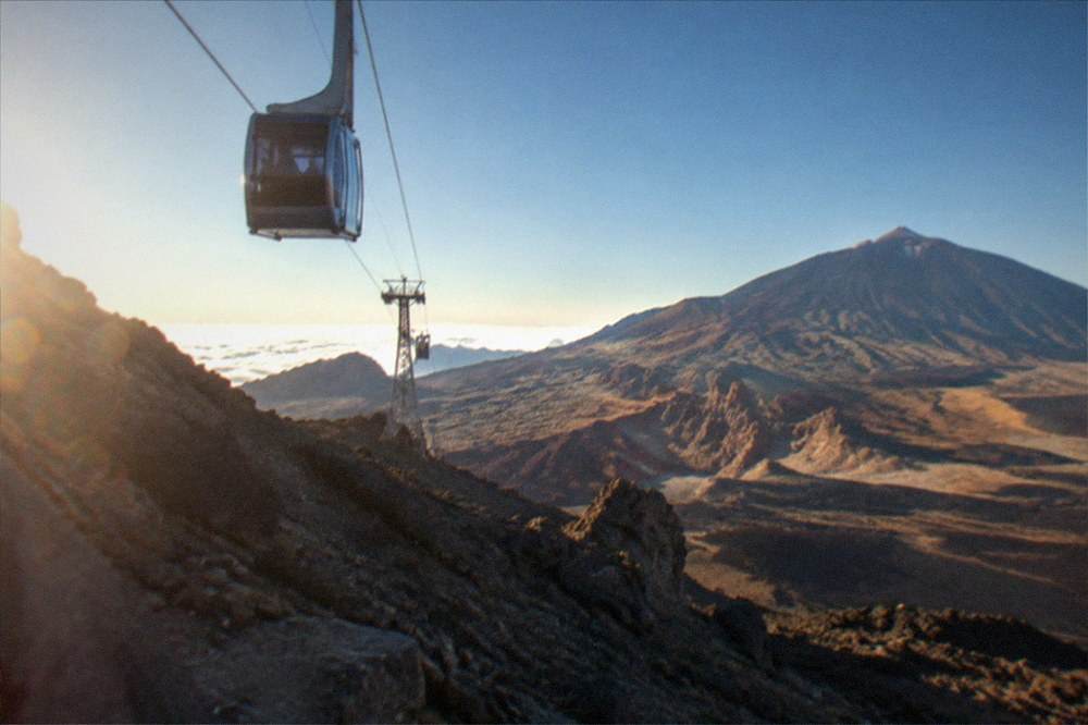 The Teide cable car cabins above volcanic rock under a cloudless sky