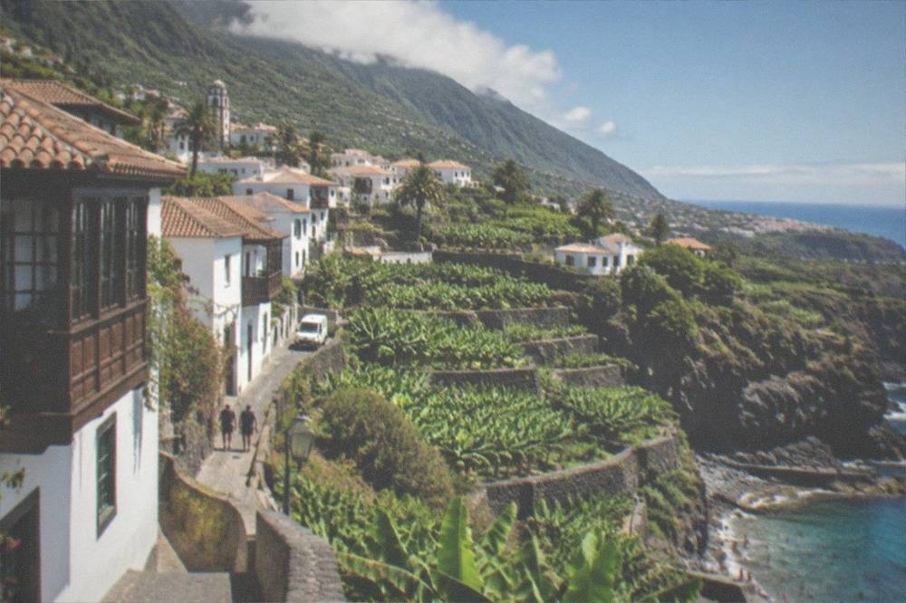 Clear blue water along a rocky southwest Tenerife coastline with bathers at the water's edge