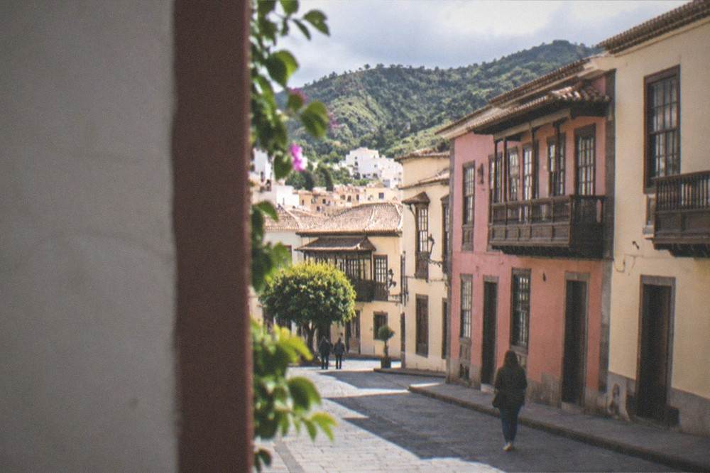 A village street in the Tenerife hills with traditional buildings and green slopes