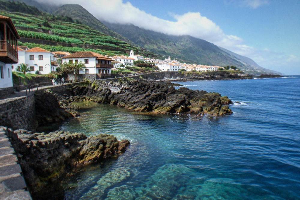 Clear blue water over rocks along the Tenerife coastline with small fish visible near the surface