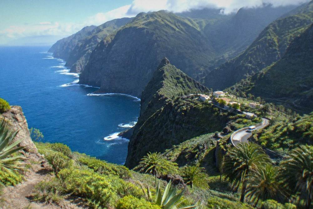 Green mountainside with low cloud over northern Tenerife and sunshine on the coast below