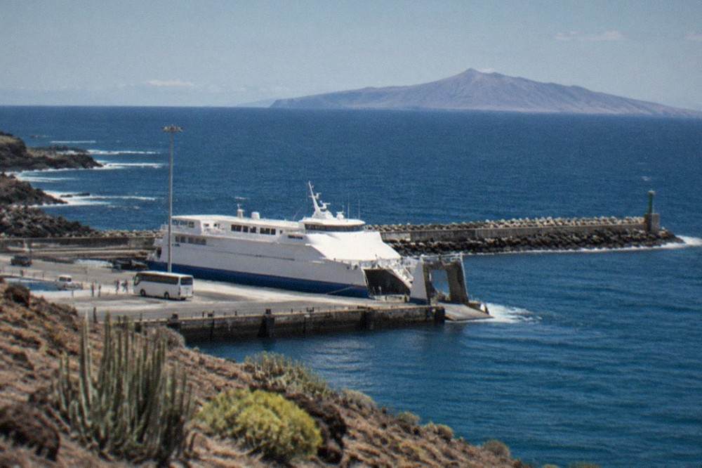 A ferry at the Los Cristianos port with the neighbouring island of La Gomera on the horizon