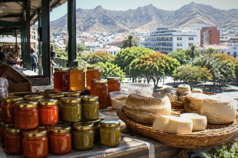 A market stall with jars of red and green Canarian mojo sauce, honey and local cheese