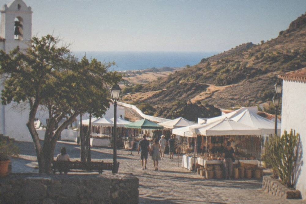 A small town square in Adeje old town with whitewashed buildings and market stalls