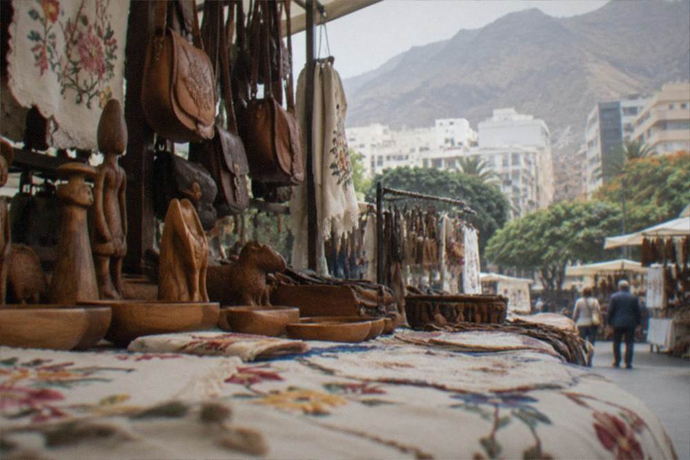 A stall of Canarian crafts including embroidery, leather bags and carved wooden items
