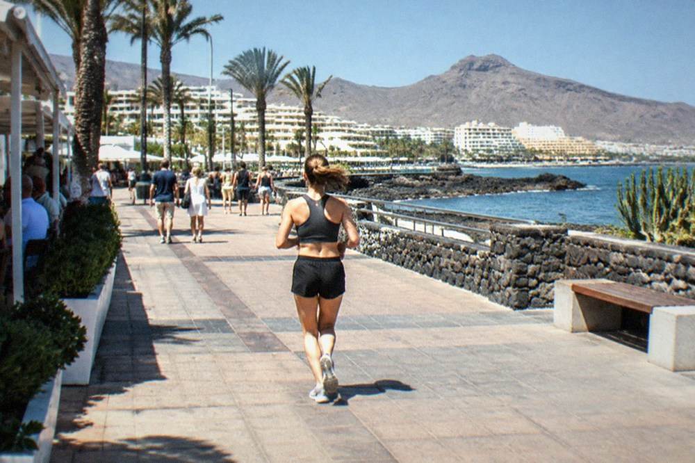 Crowds outside brightly lit venues on a warm evening in a southern Tenerife resort