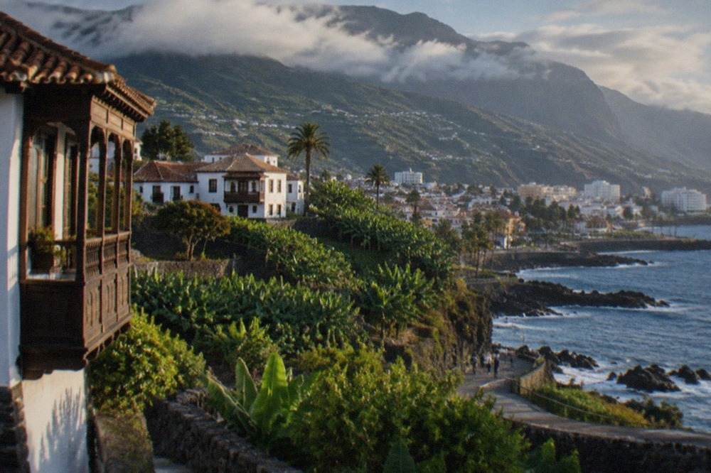 Volcanic mountain ridge rising above a resort town on the Tenerife coast