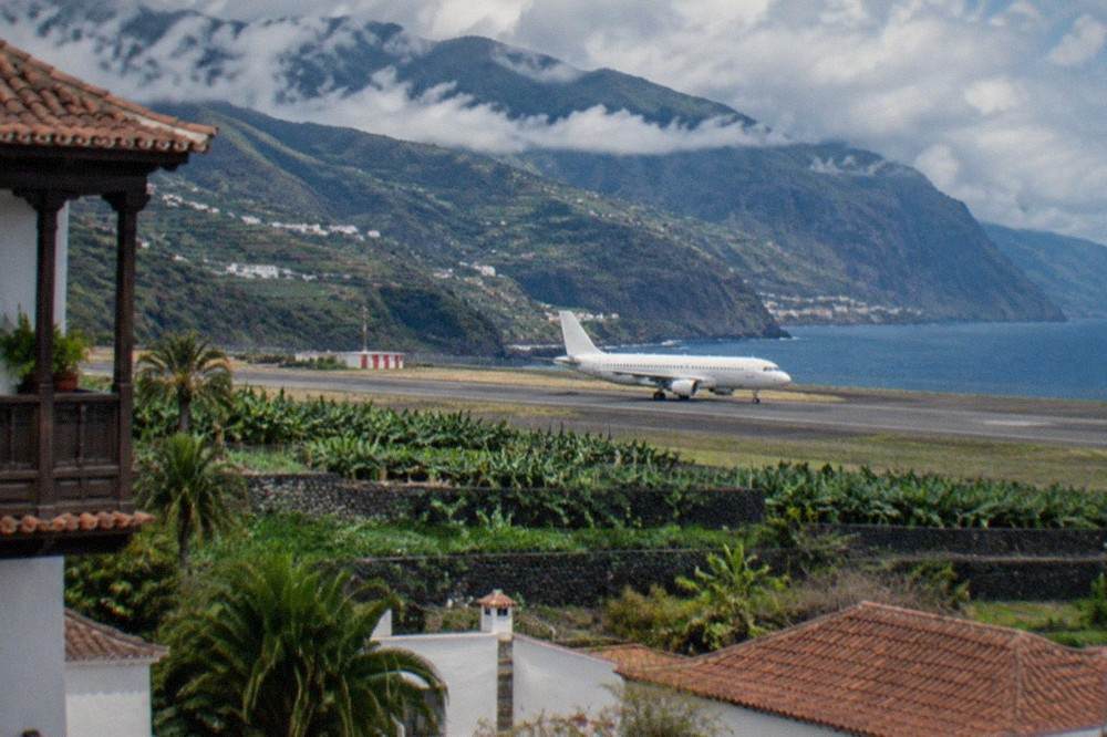 A passenger aircraft on the runway at a Canary Islands airport with mountains behind