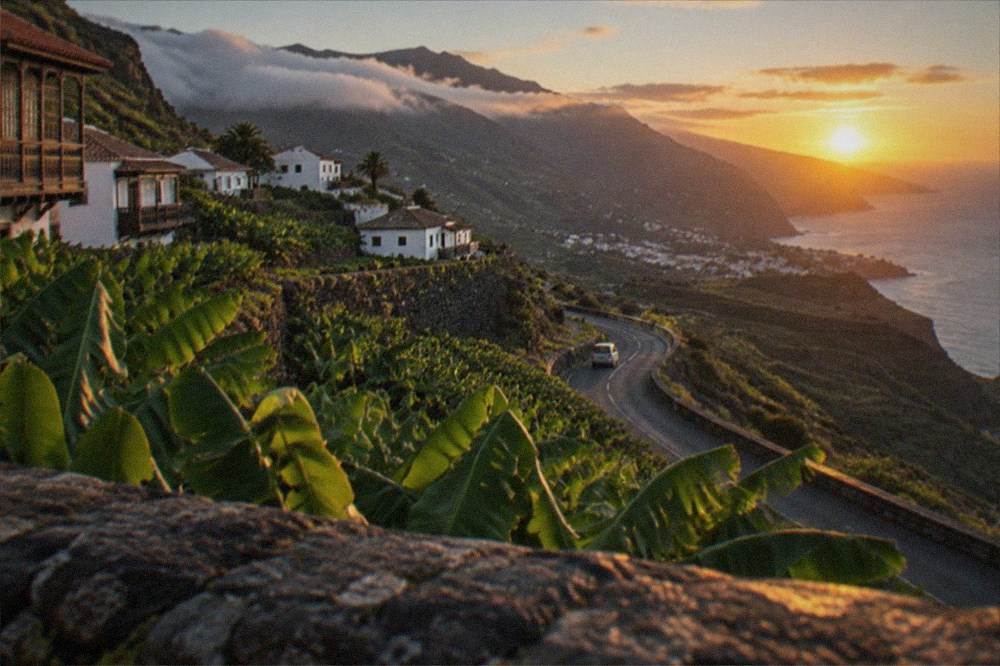 Sunset over a volcanic crater landscape with a winding mountain road