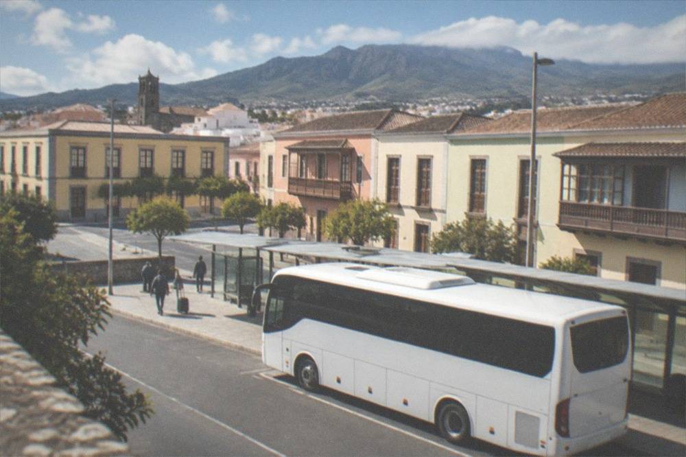 A white island bus at an airport stop under blue sky