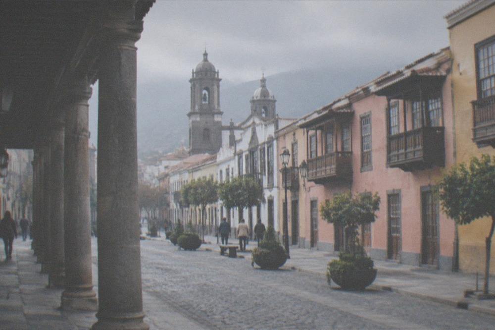 Colonnaded colonial street in La Laguna with church towers behind