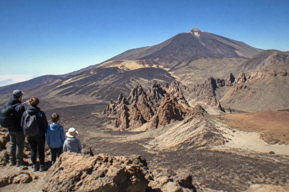 A family looking out over volcanic rock formations at a viewpoint high on Mount Teide