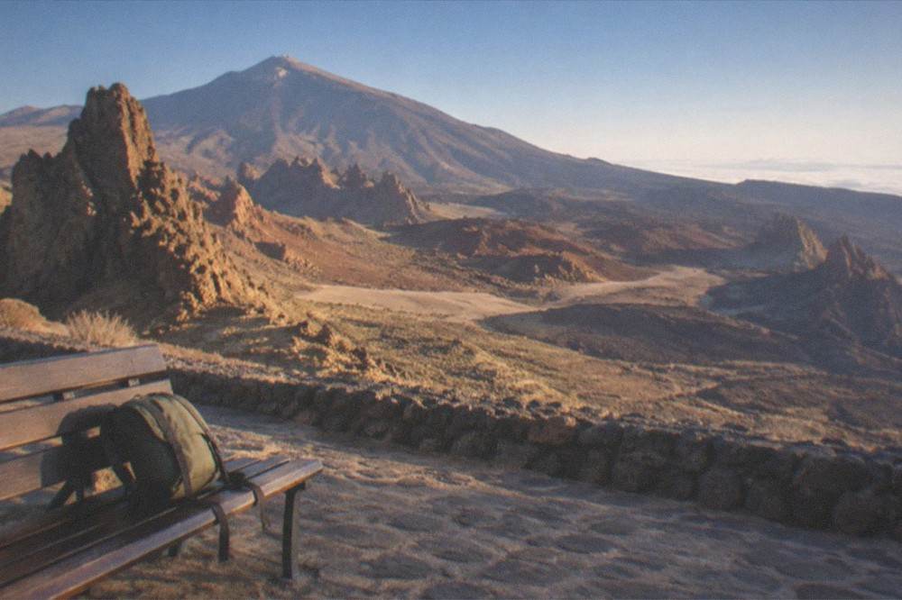A small day rucksack on a bench in a cobbled town square in evening light