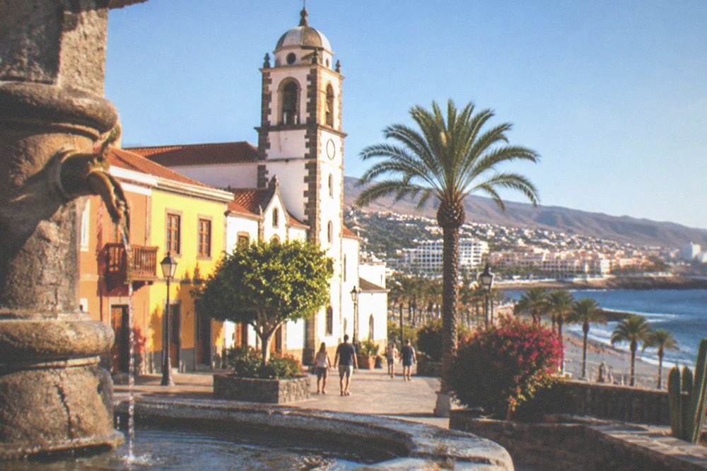 A colonial town square with colourful facades and a church tower