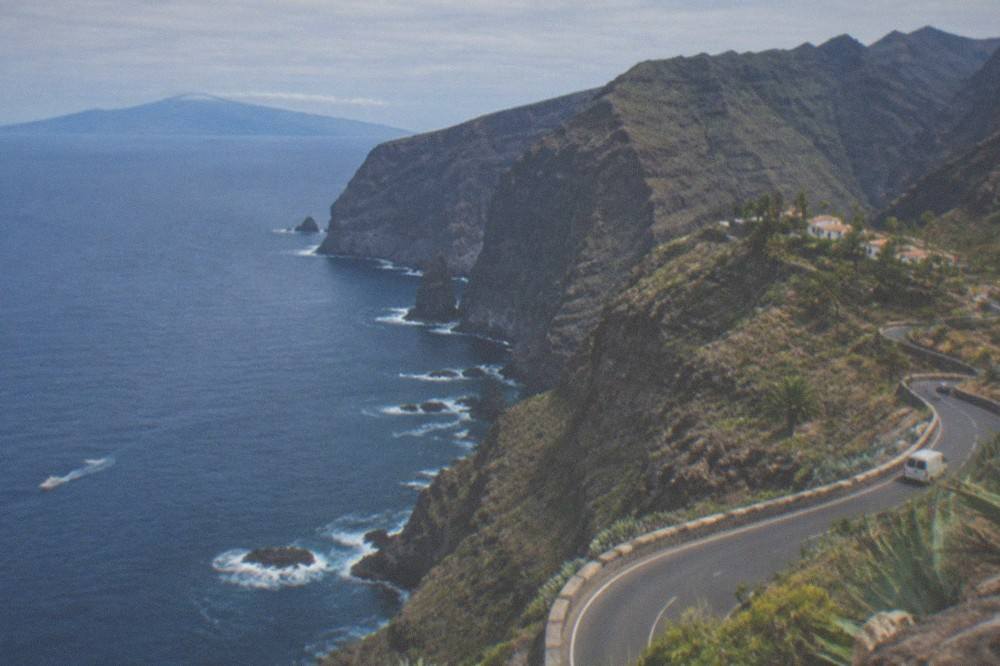 A coastal road curving along the cliffs at Los Gigantes with the ocean and La Gomera beyond