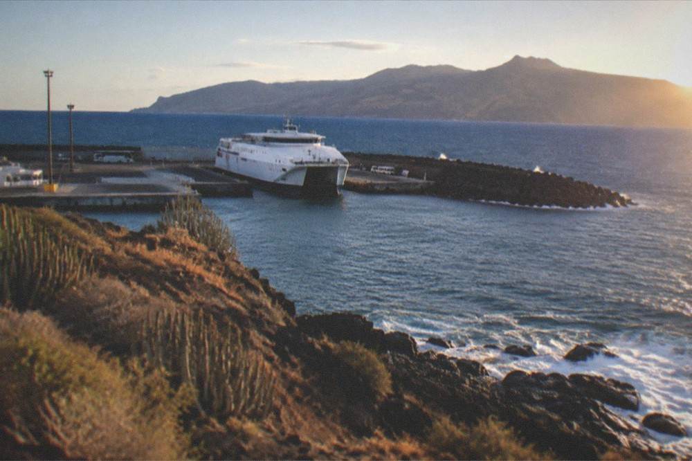 A ferry at Los Cristianos harbour with the green mountains of La Gomera on the horizon