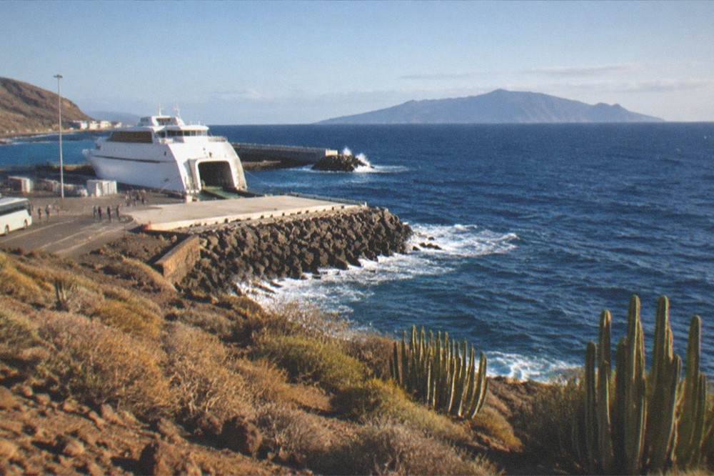 A ferry at the Los Cristianos harbour with La Gomera on the horizon