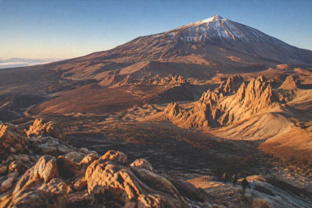 A sign beside a trail in Teide National Park under a clear winter sky