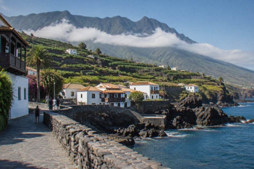 A volcanic mountain ridge above a layer of clouds on Tenerife under a clear sky