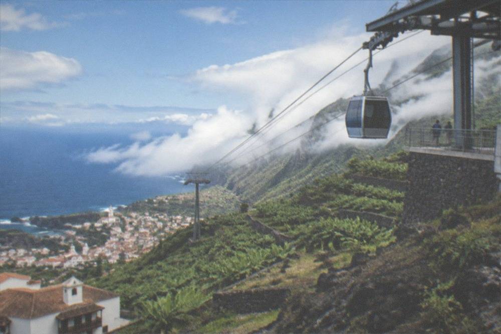 A cable car station on a rocky volcanic slope high above clouds