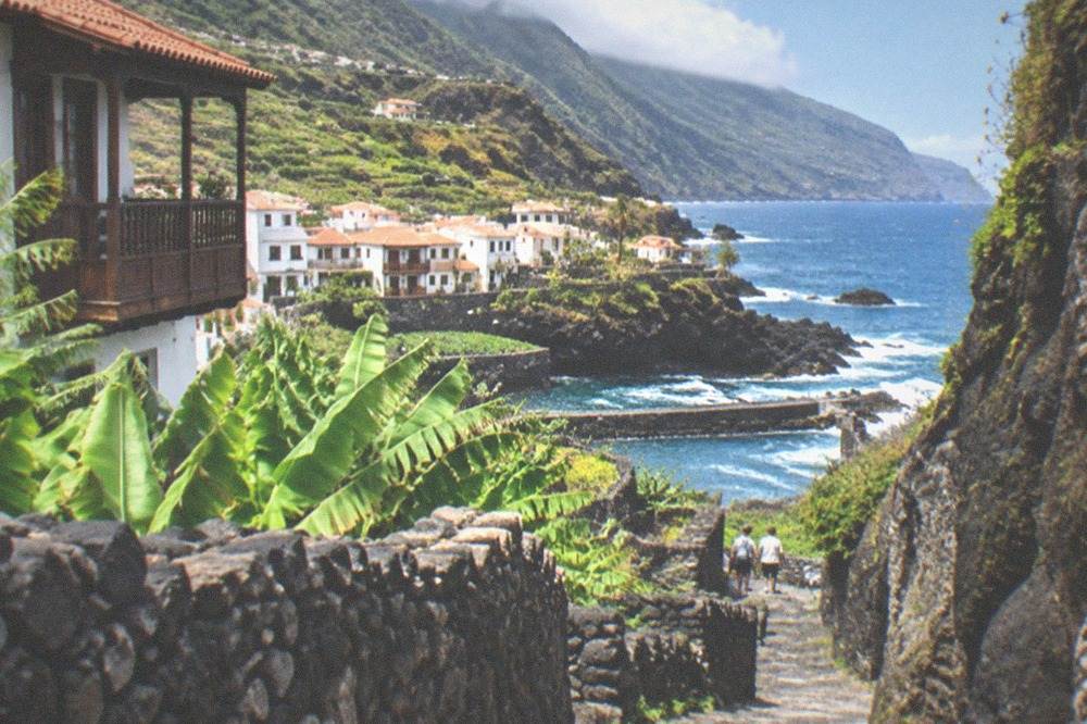 A narrow rocky gorge path descending towards a small bay