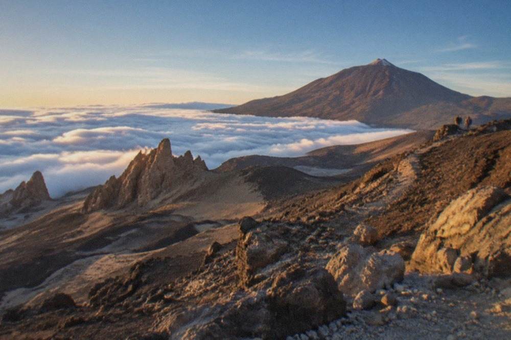 Mount Teide rising above a sea of clouds inside the national park at golden hour