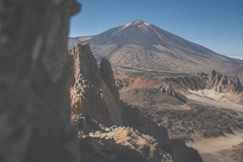The volcanic cone of Mount Teide rising above a landscape of dark rock