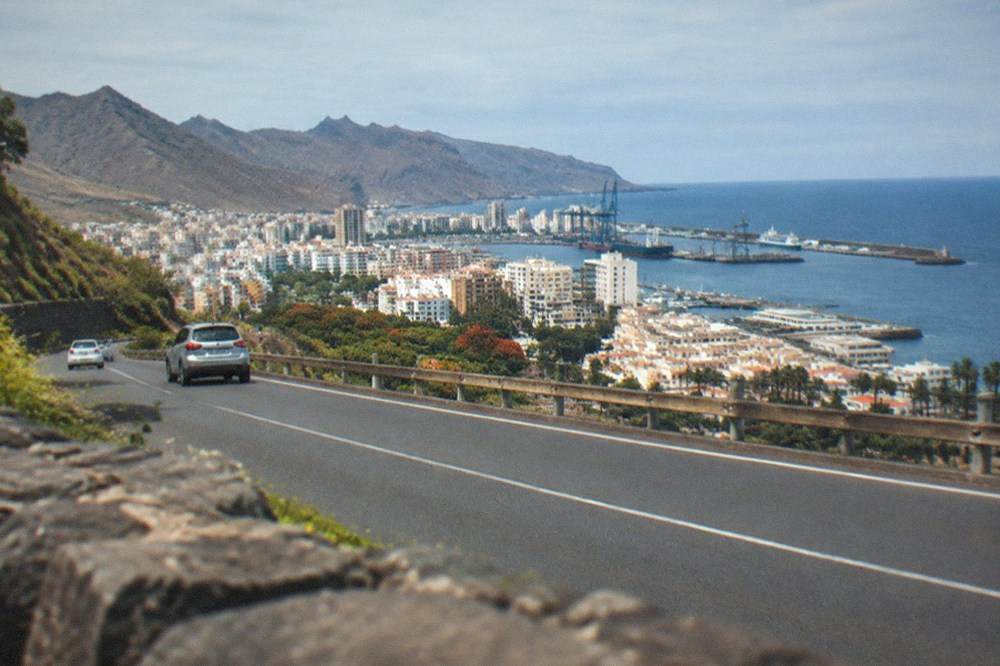 A coastal road winding between green hills and the sea on the north coast of Tenerife