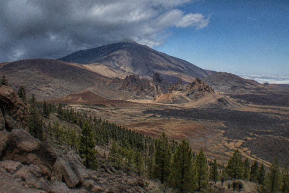 Dark rain clouds gathering over the summit of Mount Teide above pine forest