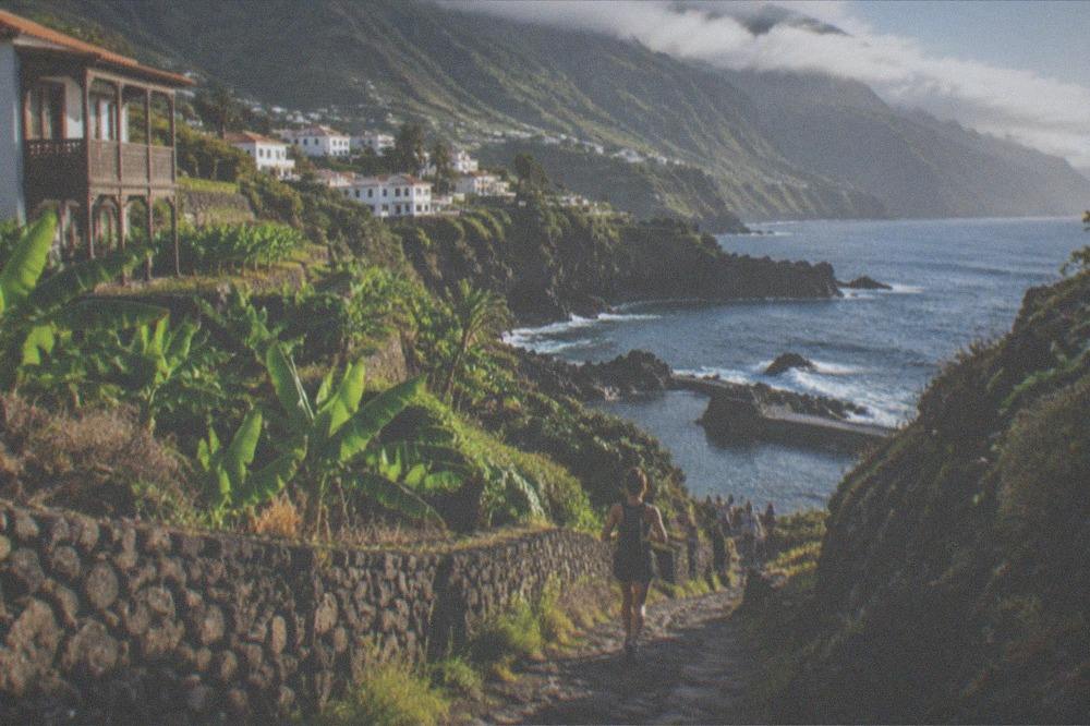 A narrow rocky gorge path descending toward a small bay