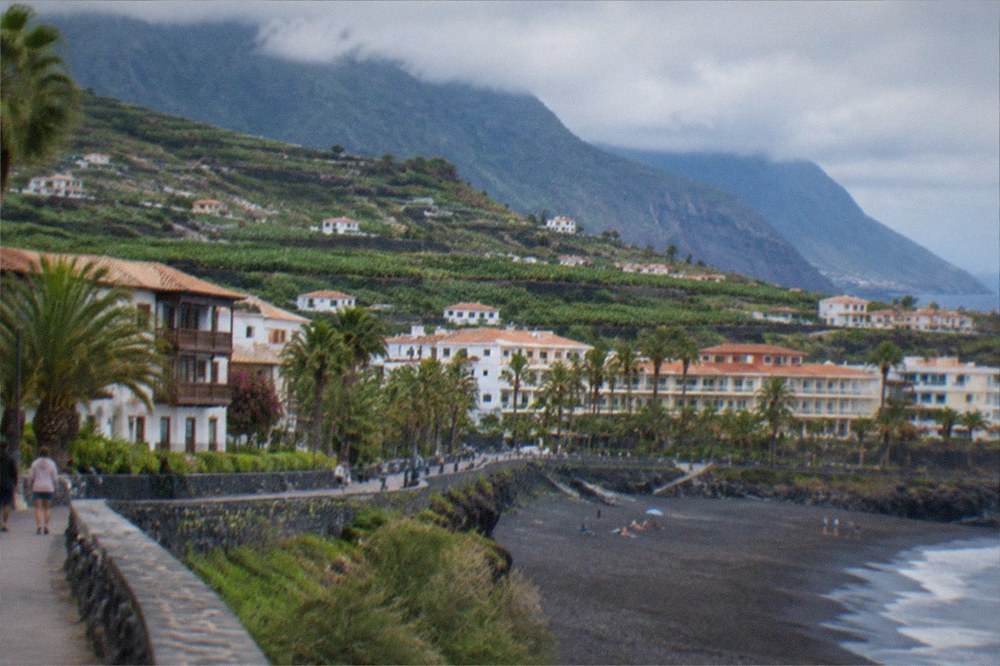 A coastal promenade in a southern Tenerife resort with hotels behind the beach