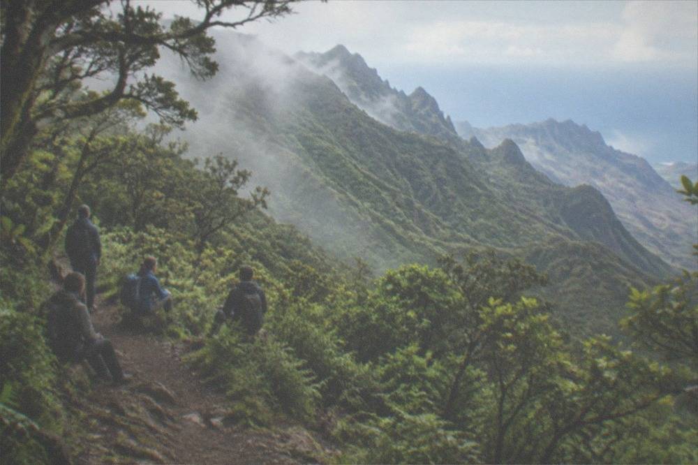 A small group resting with backpacks on a forest path in the Anaga mountains