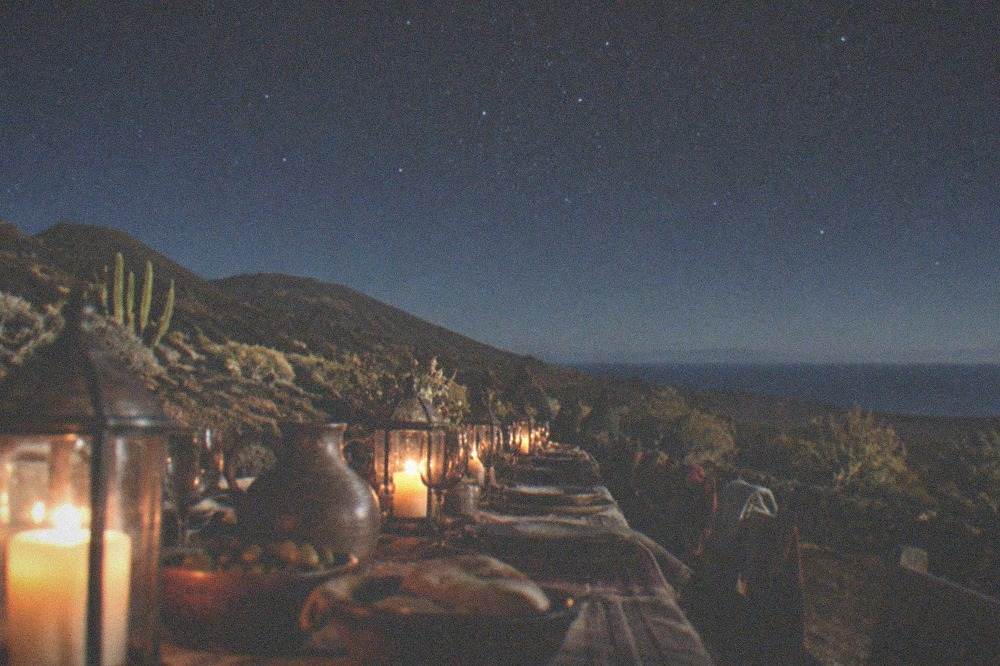 A long table set for a banquet with candles and medieval banners on the walls