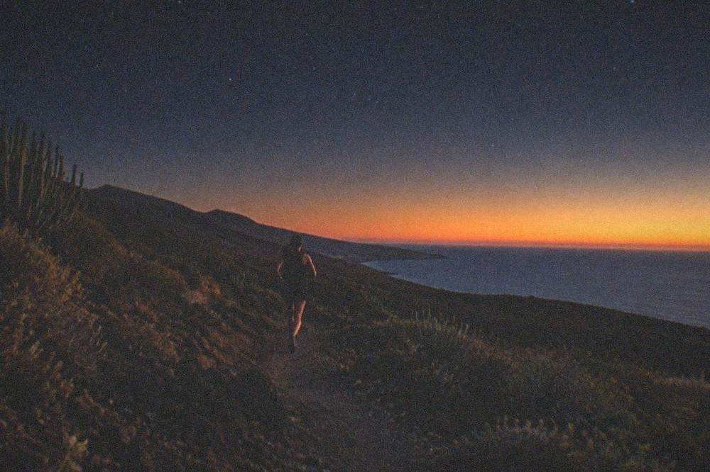 A calm sea at sunset off a Tenerife beach with the horizon glowing