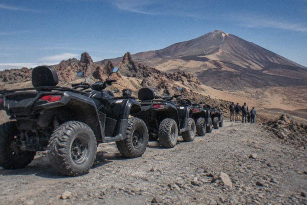 A line of quad bikes parked on a volcanic track high on Mount Teide
