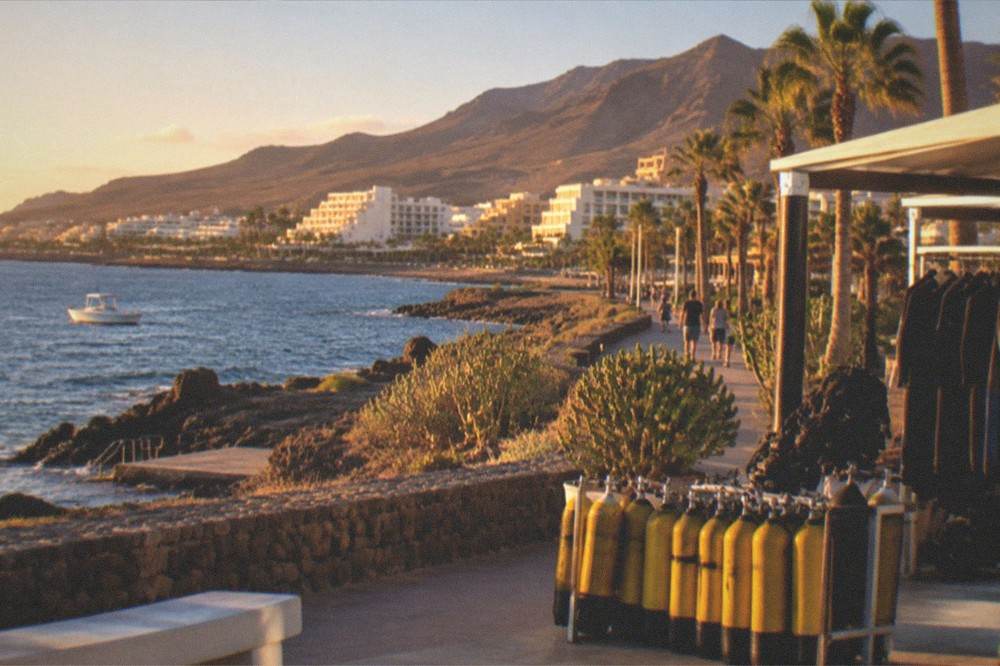 A dive centre on a seafront promenade with dive tanks lined up outside
