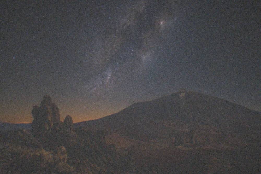 The night sky over Teide National Park with a bright band of stars above the dark volcano